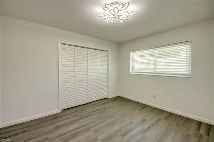 Unfurnished bedroom featuring light wood-style floors and a closet