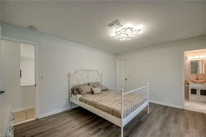 Bedroom with wood finished floors and connected bathroom