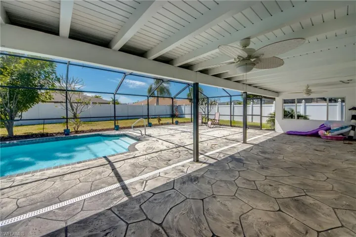 View of swimming pool featuring a sunroom, patio surround, glass enclosure, and a fenced backyard