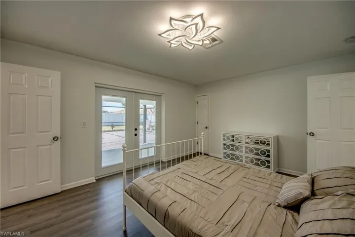 Bedroom with french doors, access to outside, and dark wood finished floors