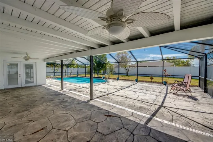 View of pool with patio surround, a fenced backyard, a sunroom, a lanai, and french doors