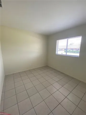 Front Guest bedroom features natural lighting and tile flooring