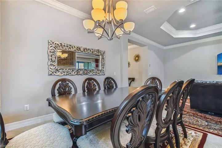 Dining room featuring crown molding, a chandelier, and a tray ceiling