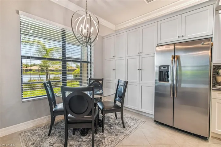 Dining area with a chandelier, crown molding, light tile patterned floors, and a water view