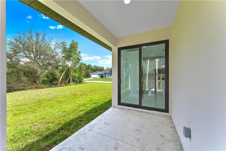 Doorway to property featuring a yard and a patio