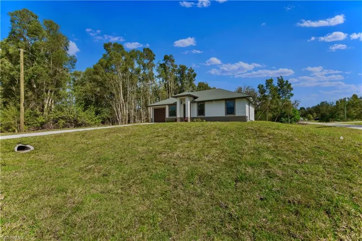 View of front of home with a garage and a front yard