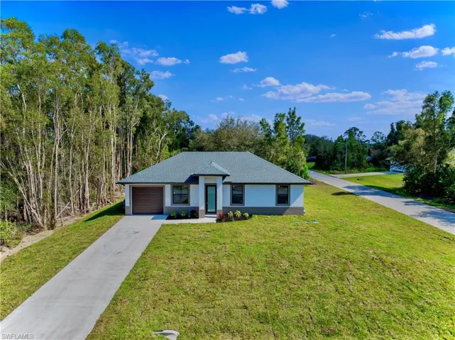 Single story home with a garage and a front yard