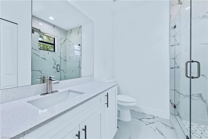 Bathroom featuring vanity, toilet, and walk in shower