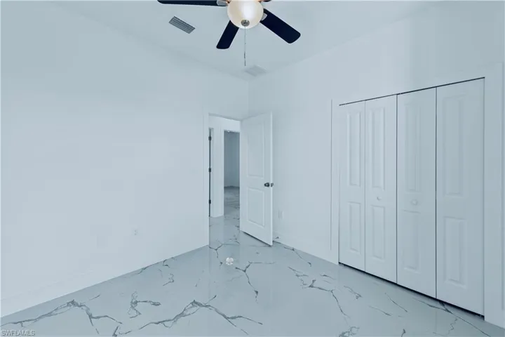 Unfurnished bedroom featuring ceiling fan and a closet