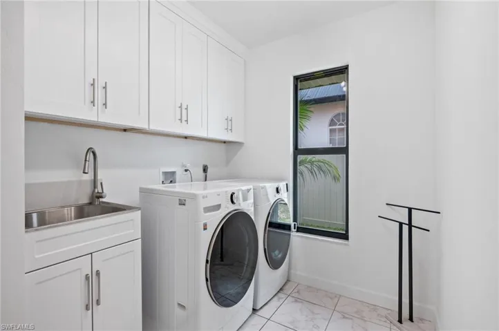 Huge Indoor laundry room with lots of cabinets and laundry sink
