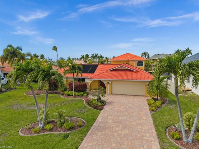 Long Paver driveway and tropical landscaping make a stately entrance!