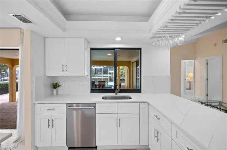 Kitchen overlooks the lanai, pool and canal
