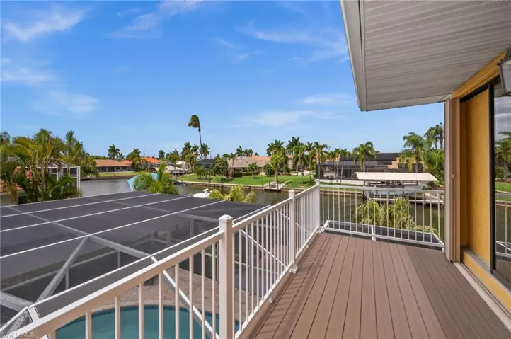 Upstairs Primary balcony with views of the pool and canal