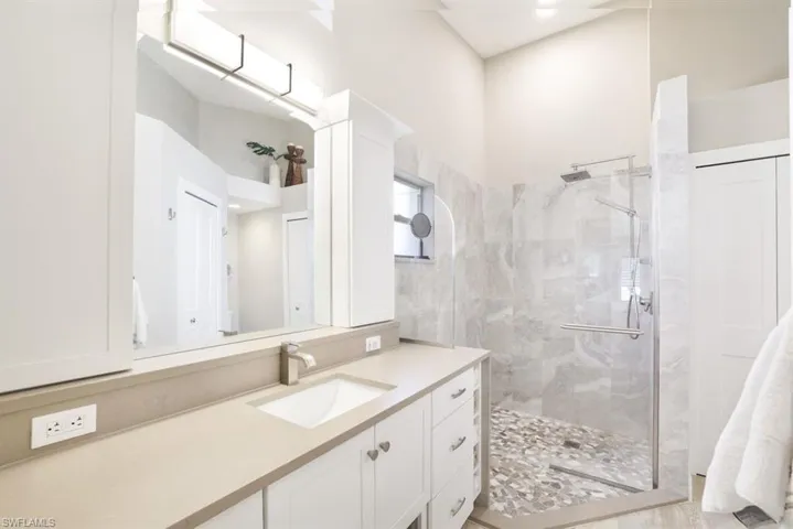 Bathroom featuring a shower with door and vanity