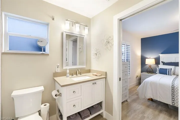 Bathroom with hardwood / wood-style flooring, vanity, and toilet