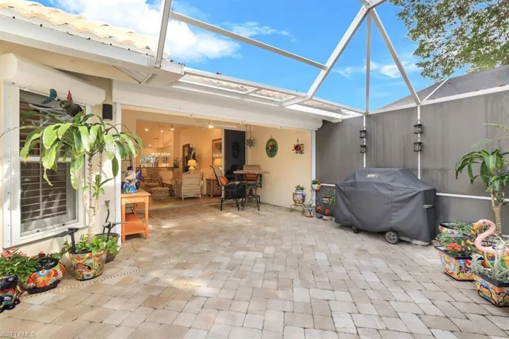 View of patio featuring a grill and glass enclosure