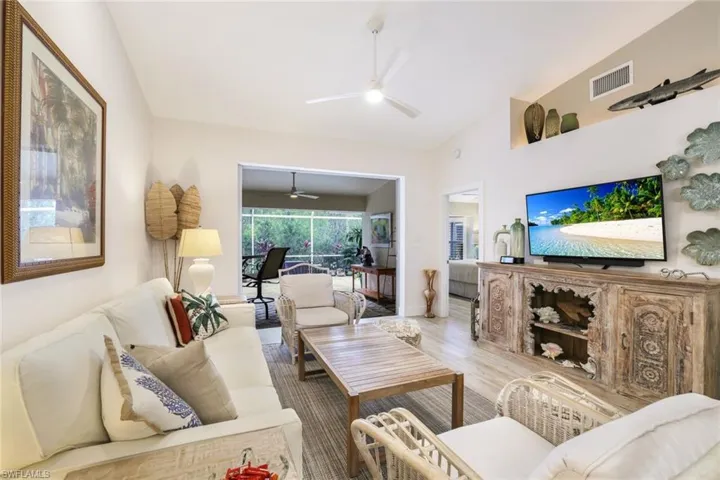 Living room with hardwood / wood-style flooring, high vaulted ceiling, and ceiling fan