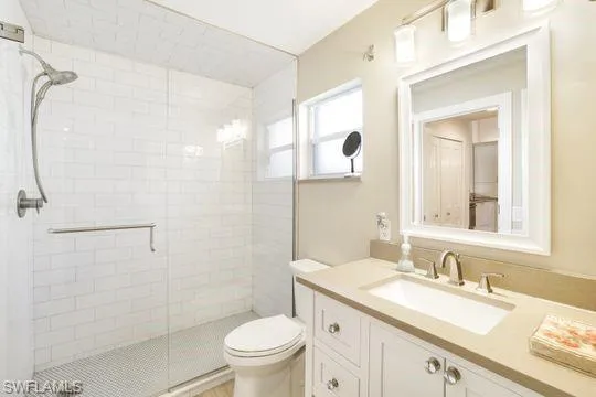 Bathroom featuring vanity, toilet, and a shower with shower door