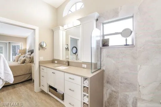 Bathroom featuring vanity, wood-type flooring, and tiled shower