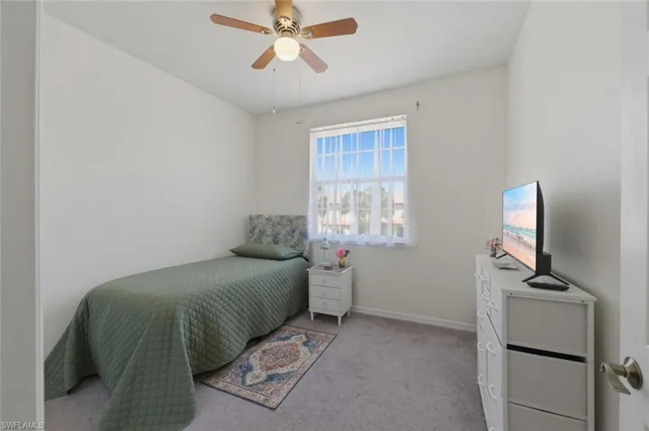 Bedroom with light colored carpet and ceiling fan