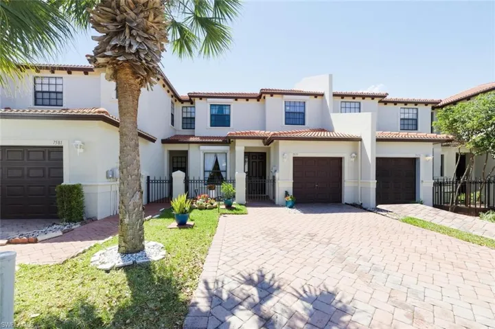 Mediterranean / spanish home featuring decorative driveway, stucco siding, an attached garage, and a tiled roof