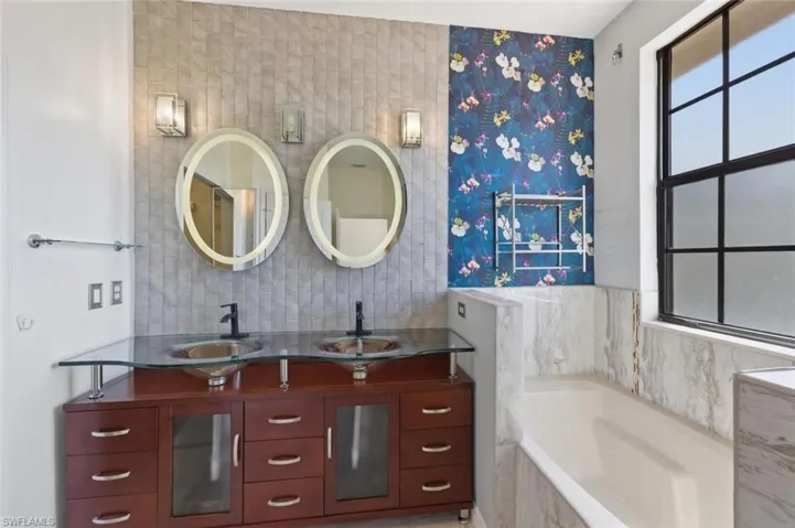 Bathroom with double vanity, a garden tub, and decorative backsplash