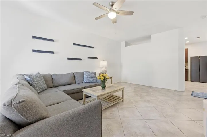 Living room featuring recessed lighting, ceiling fan, and light tile patterned floors