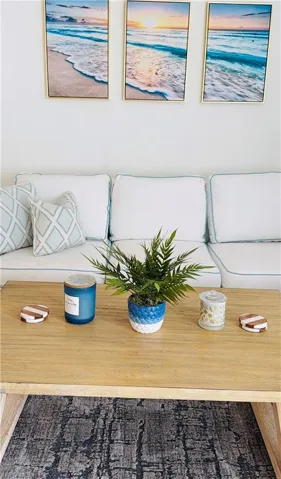 White sofa with light blue piping and patterned throw pillows