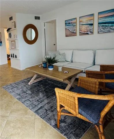 Spacious living area featuring tile flooring, built-in shelving, and a neutral color palette