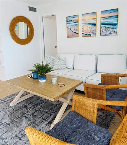 Bright living area featuring tiled flooring, a light wood-finish coffee table, and white walls