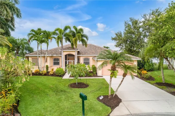 View of front of property with a garage and a front lawn
