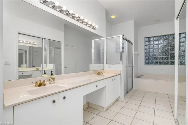 Bathroom with separate shower and tub, tile patterned floors, and double sink vanity