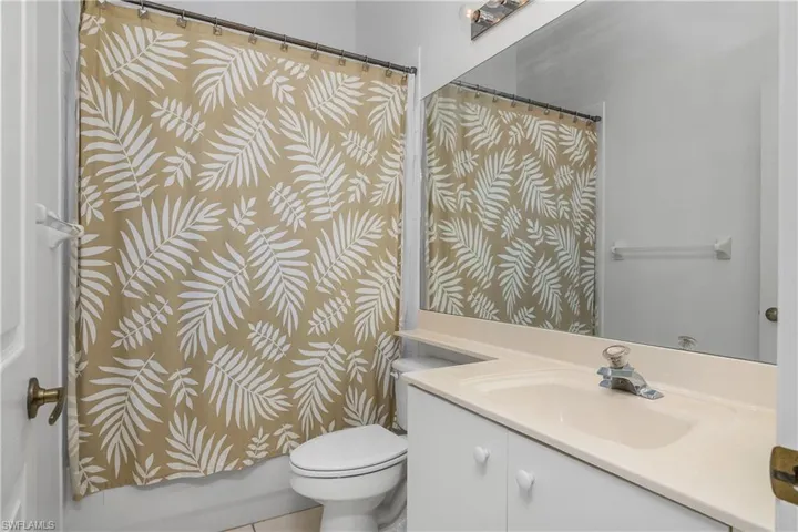 Full bathroom featuring shower / bath combo with shower curtain, vanity, and toilet