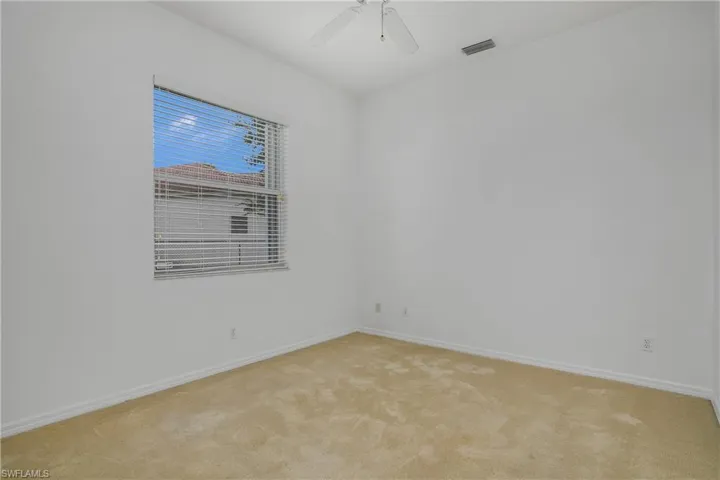 Carpeted spare room featuring ceiling fan