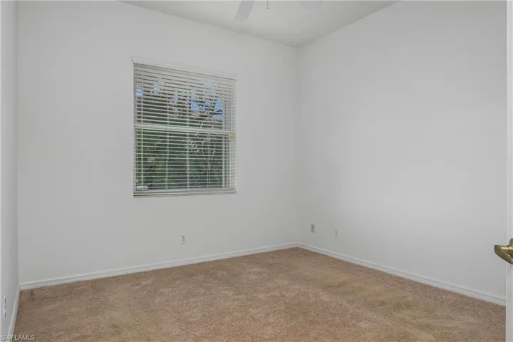 Carpeted empty room featuring ceiling fan