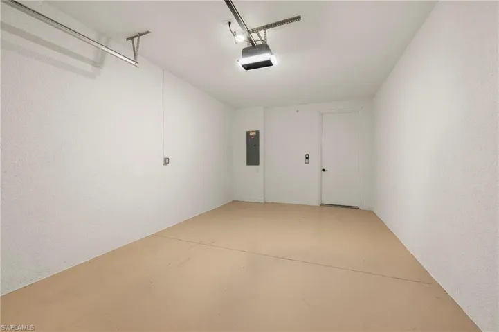 Garage featuring electric panel and a garage door opener