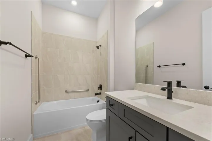 Full bathroom featuring tub / shower combination, toilet, tile patterned flooring, and vanity