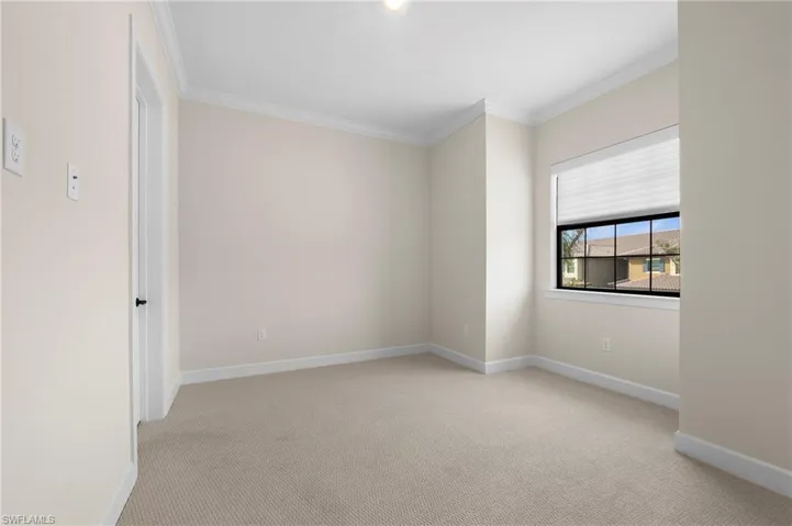 Carpeted spare room featuring baseboards and ornamental molding