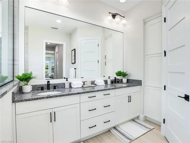 Bathroom featuring double vanity, recessed lighting, and ensuite bathroom