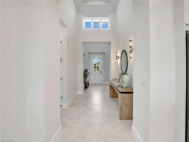 Hallway with a high ceiling and baseboards