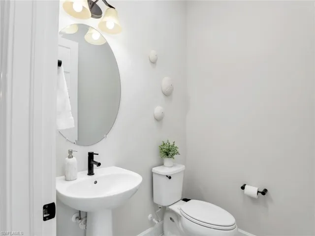Half bath with toilet and baseboards