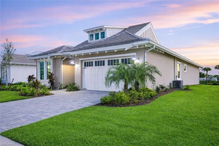 View of front of home featuring driveway, a yard, stucco siding, and an attached garage