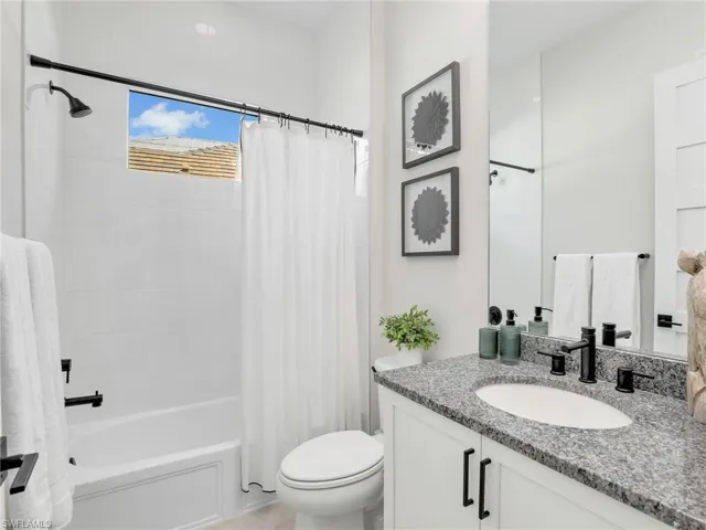 Bathroom with vanity and shower / tub combo with curtain