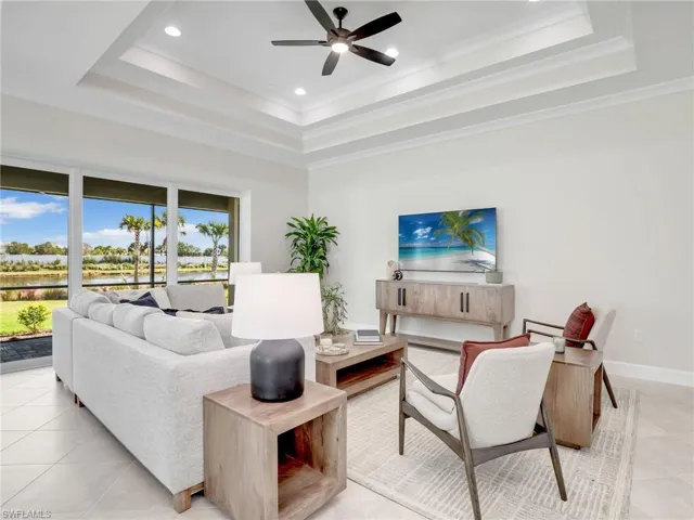 Living room featuring a ceiling fan, recessed lighting, light tile patterned floors, a water view, and ornamental molding
