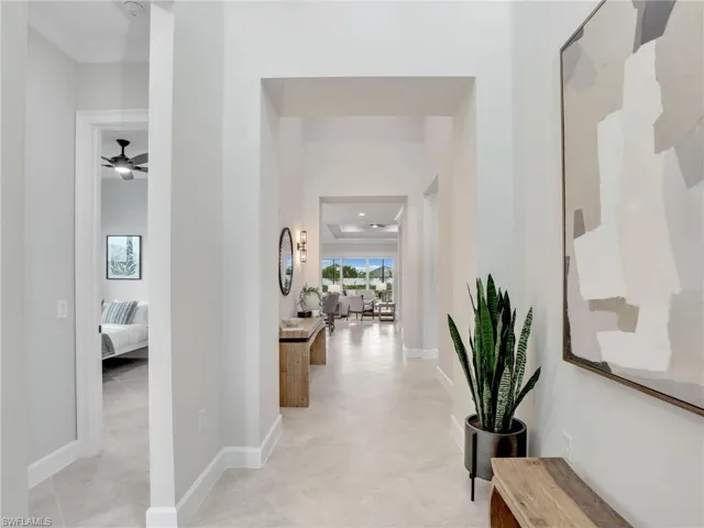 Hallway featuring a tray ceiling and baseboards