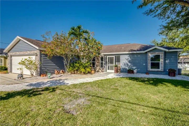 Ranch-style house with an attached garage, a front lawn, and concrete driveway