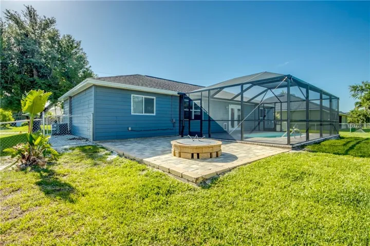 Rear view of house with a patio area, an outdoor pool, a fire pit, and a lanai