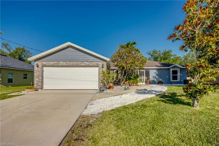 Ranch-style house with a front yard and concrete driveway