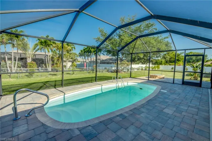 View of swimming pool with a patio and glass enclosure