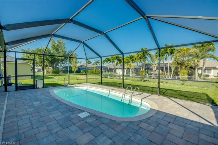 Swimming pool featuring a patio area, a yard, and a residential view